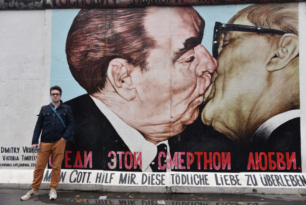 Zdjęcie Marcina przed muralem Braterski Pocałunek