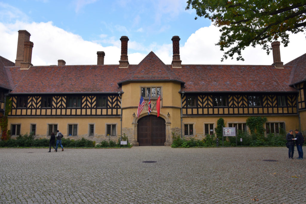 Poczdam - pałac Cecilienhof  - brama z wiszącymi nad nią flagami