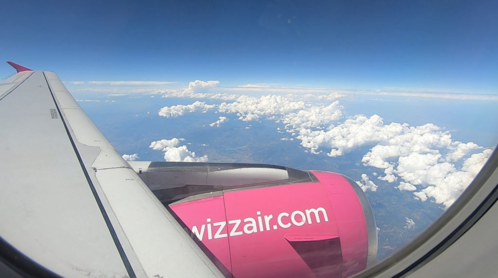 Widok na silnik Airbusa A320 linii Wizz Air przez okno podczas lotu