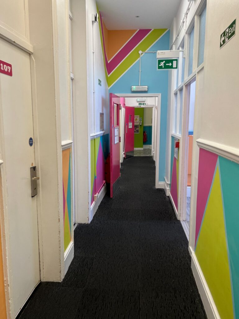 Tani nocleg centrum Londynu Smart Russell Square Hostel korytarz w pastelowych kolorach