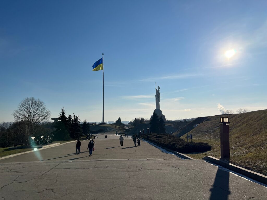 Pomnik Matka Ojczyzna i flaga Ukrainy w Kijowie w słoneczny zimowy mroźny dzień z oddali