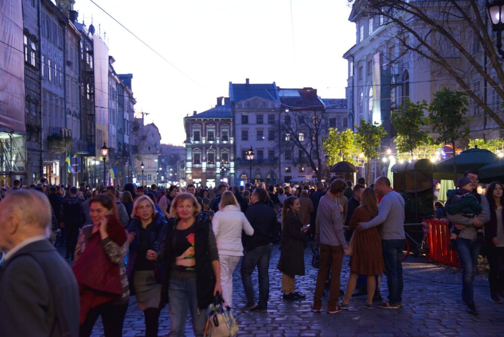 Turyści spacerujący wieczorem po lwowskim rynku w pogodny wieczór