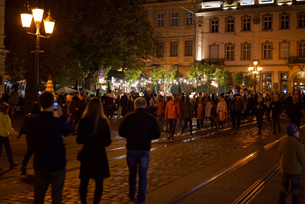 Rynek we Lwowie po zmroku i tłum oglądający tancerzy tango
